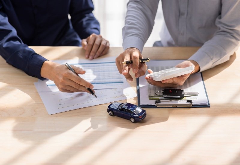 People doing calculations on the cost of car insurance in the Grand Junction area